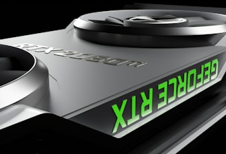 Close-up of a graphics card featuring two large cooling fans and the text 'GEFORCE RTX' displayed in green. The metallic surface has a sleek, modern design with embossed characters 'RTX 2080 Ti'.